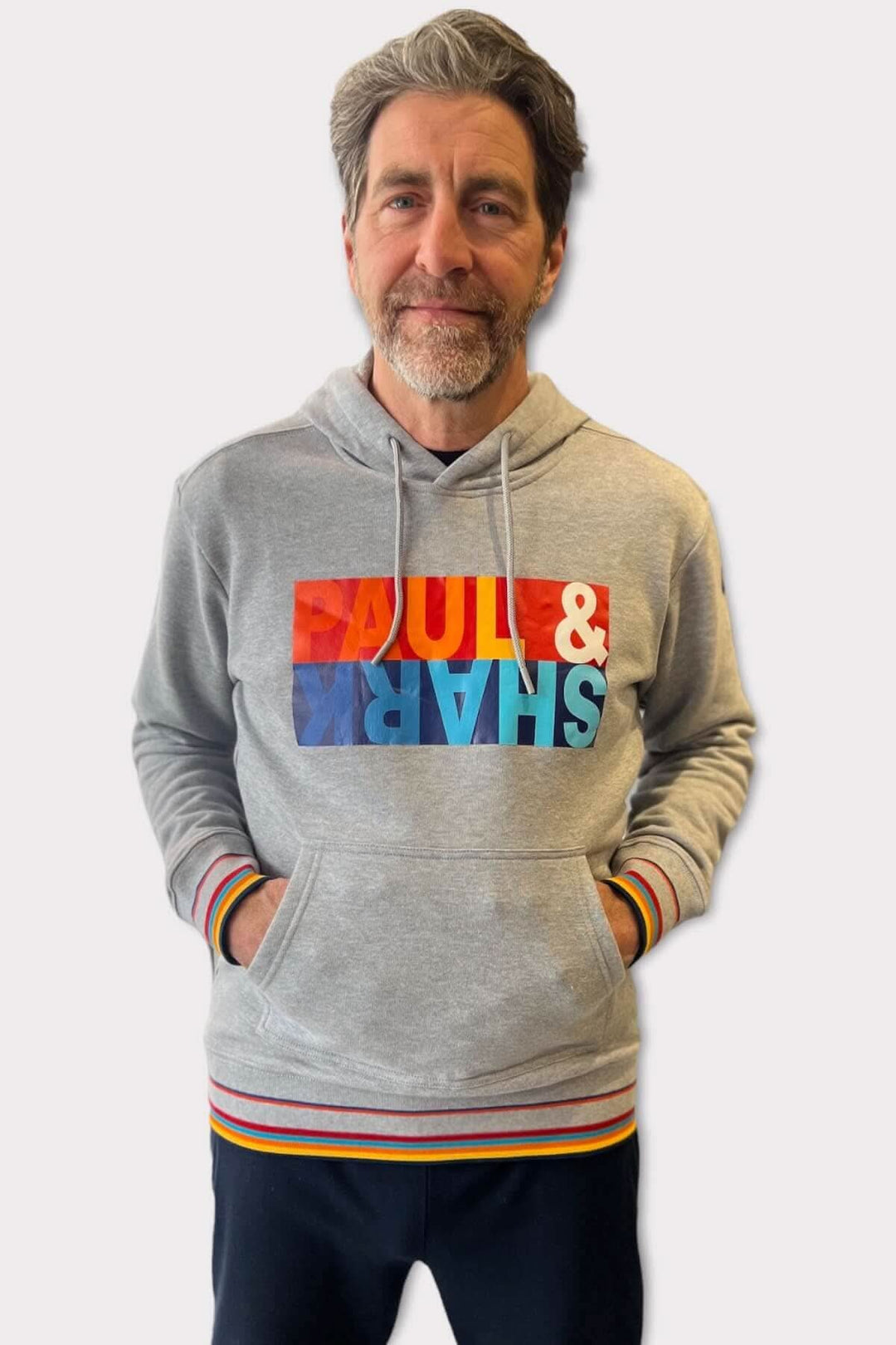 Homme portant un coton ouaté gris Paul and Shark avec logo coloré, idéal pour les journées fraîches.