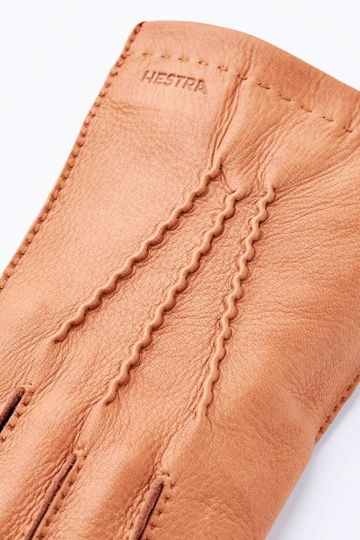 Gant de conduite en cuir beige de la collection Hestra, présentant des finitions de haute qualité et un design élégant.