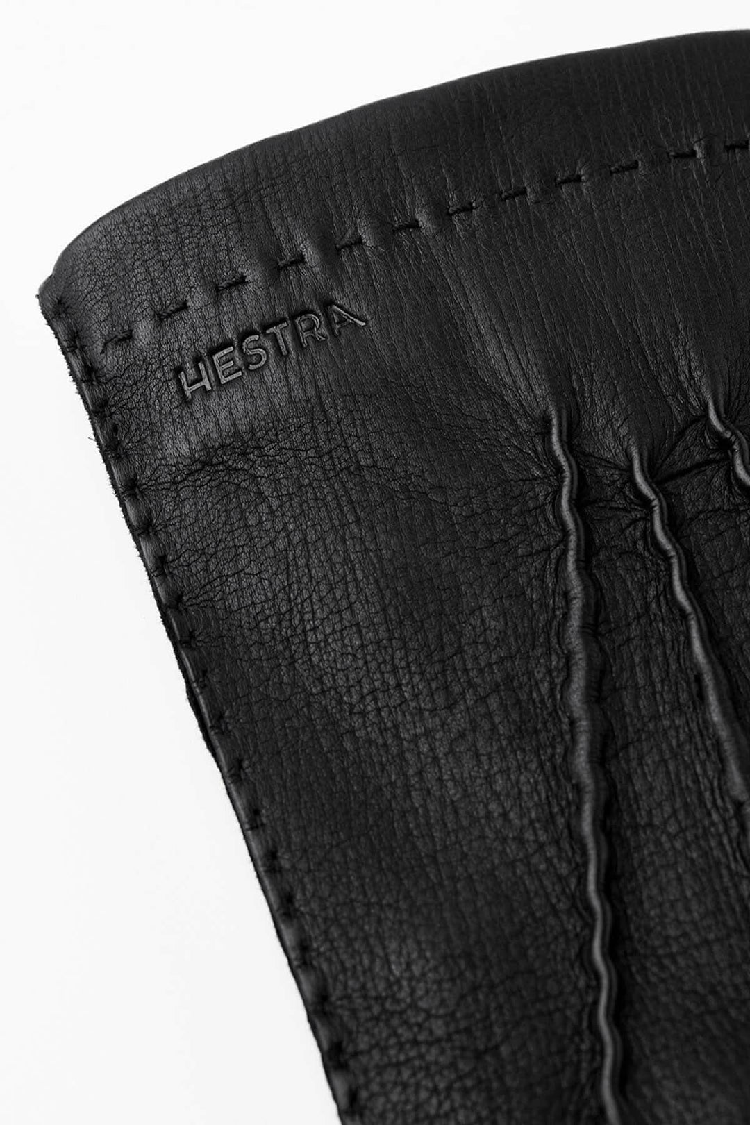 Gant de conduite en cuir noir de la collection Hestra, mettant en avant la texture et les finitions précises.