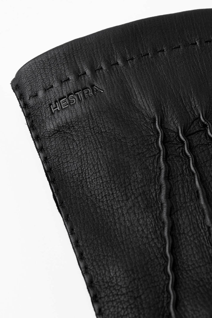 Gant de conduite en cuir noir de la collection Hestra, mettant en avant la texture et les finitions précises.
