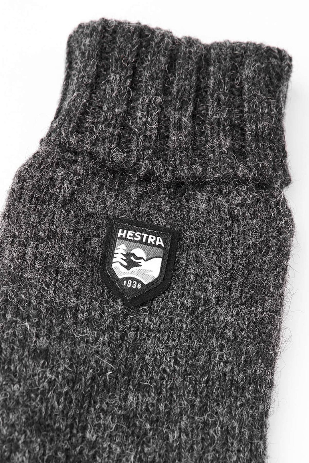 Gant en laine gris avec logo Hestra, idéal pour garder les mains au chaud et au sec.