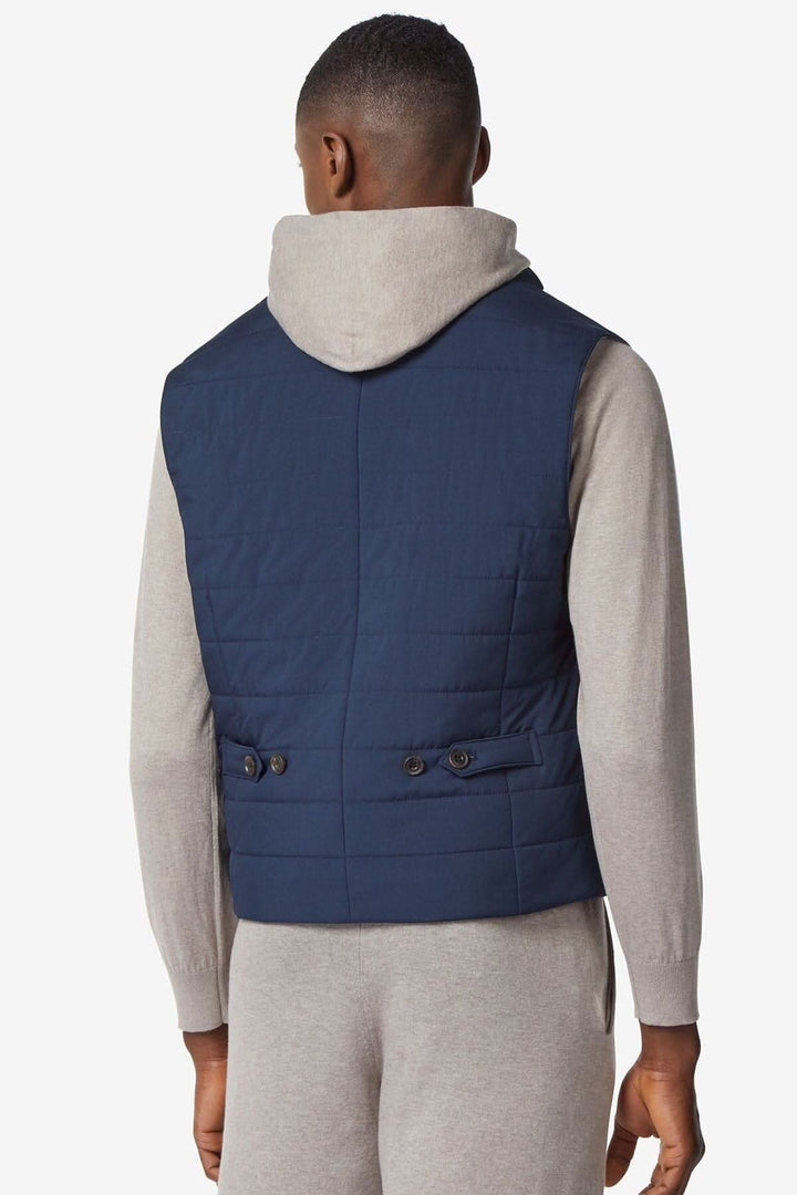Vue arrière d'un gilet déperlant rembourré bleu foncé, associé à un sweat gris, élégant et sportif.