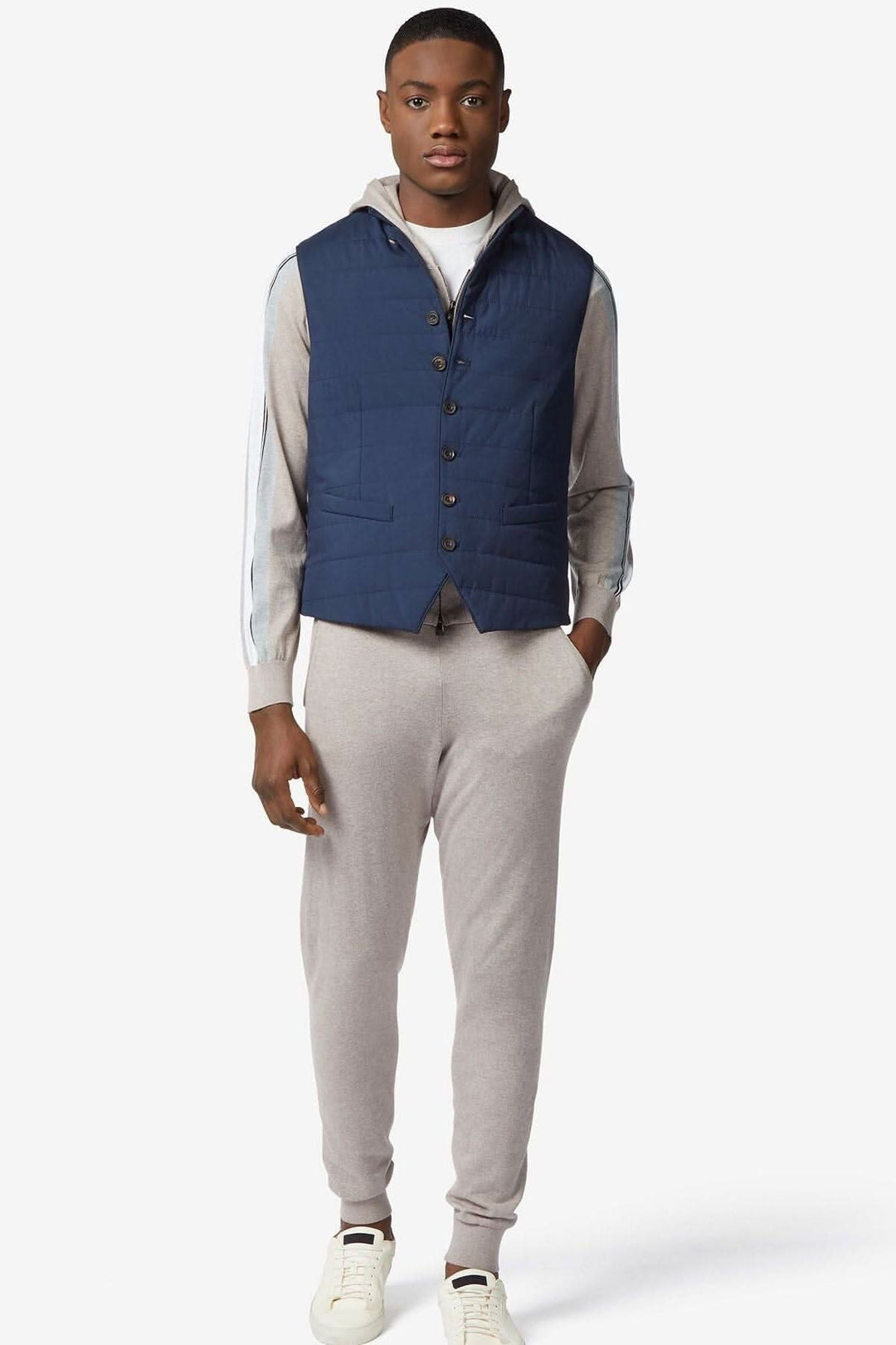 Gilet déperlant rembourré bleu foncé porté par un homme avec un look sportif et élégant.