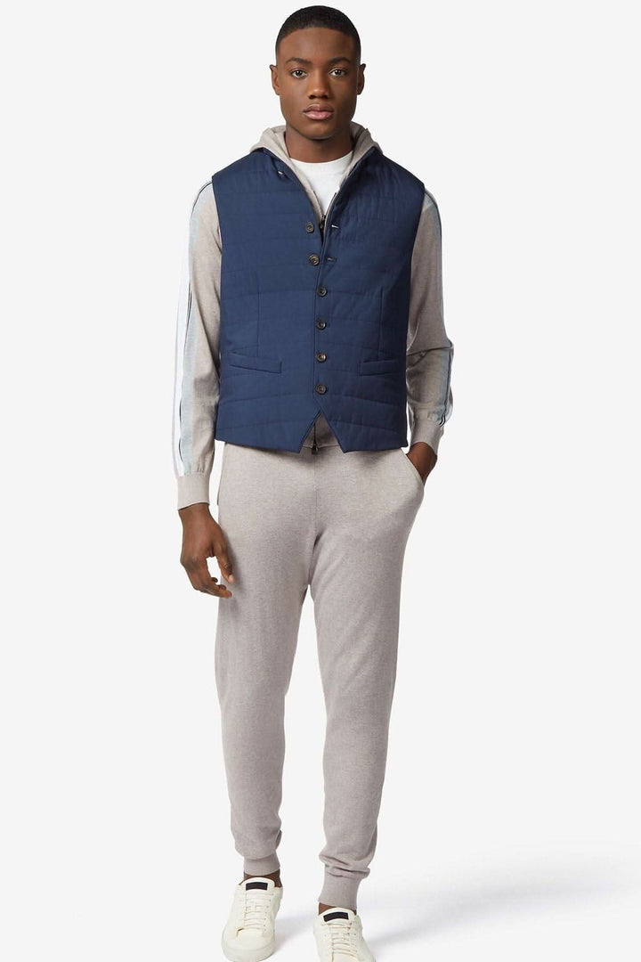 Gilet déperlant rembourré bleu foncé porté par un homme avec un look sportif et élégant.