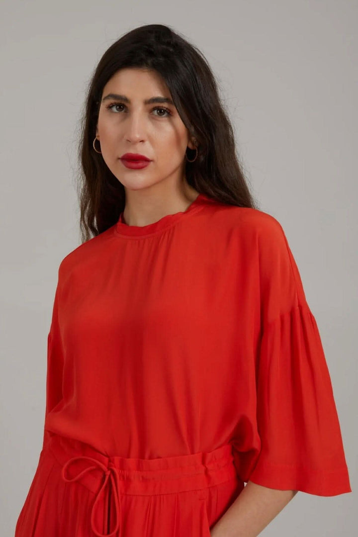 Haut rouge à manches midi avec une coupe ample, idéal pour une tenue décontractée ou habillée.