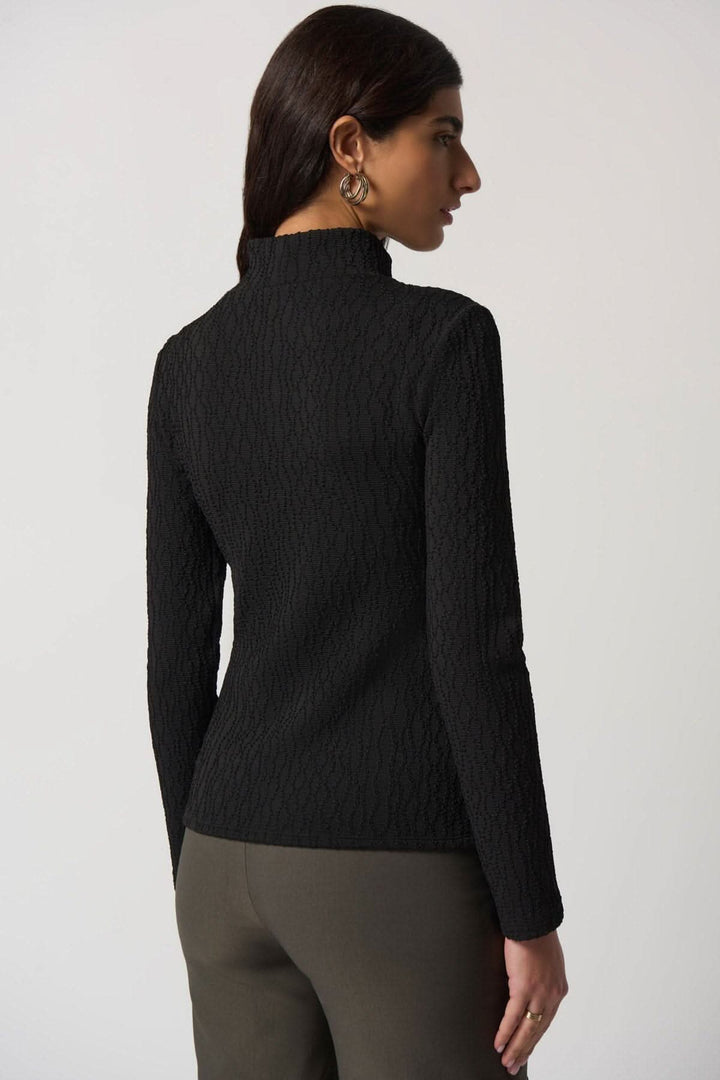 Haut texturé col montant noir vu de dos, parfait pour l'automne, avec tissu enveloppant et légèrement cintré.