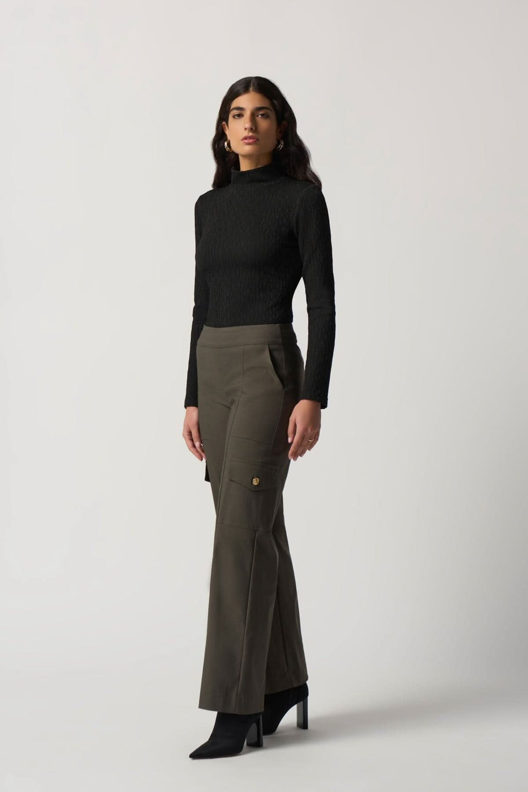 Haut texturé col montant noir associé à un pantalon cargo olive, parfait pour les journées fraîches.