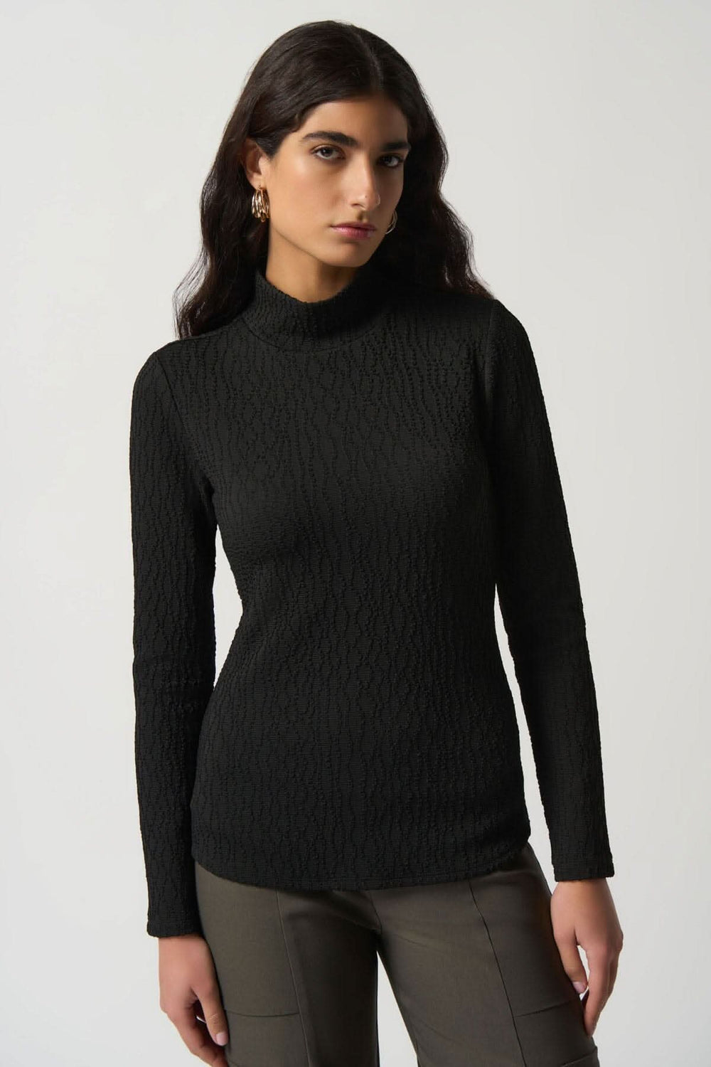 Haut texturé col montant noir, manches longues, idéal pour les journées fraîches, porté avec un pantalon.