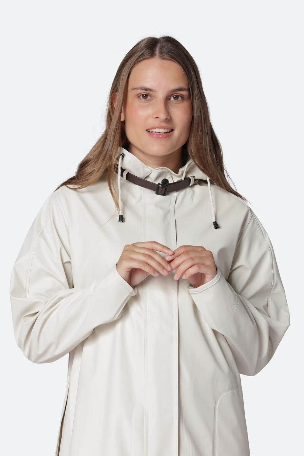 Femme souriante portant un imperméable léger avec capuche détachable et poches latérales.