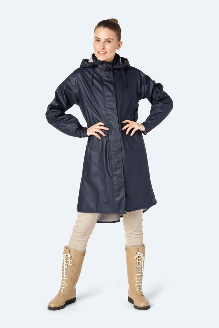 Femme portant un imperméable léger bleu marine avec capuche, dans un style moderne et décontracté.