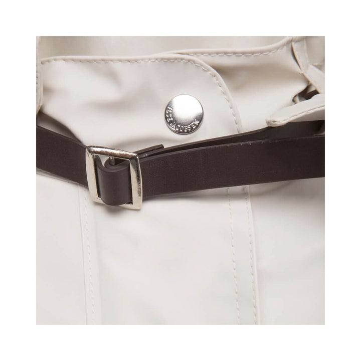 Détail de la sangle en cuir artificiel et bouton d'un imperméable féminin léger.
