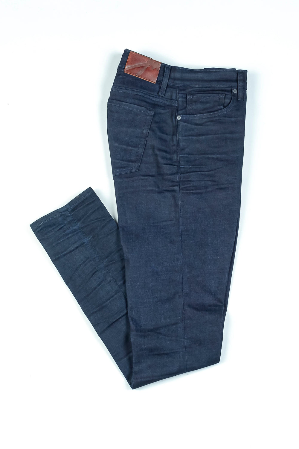 Jean Blade Cobolt en denim bleu turquoise avec une finition brute et plis faits à la main, style distinctif.