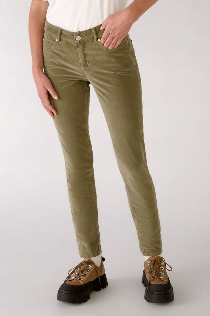 Jean Baxter en velours olive, coupe skinny, idéal pour un look décontracté avec un haut blanc.