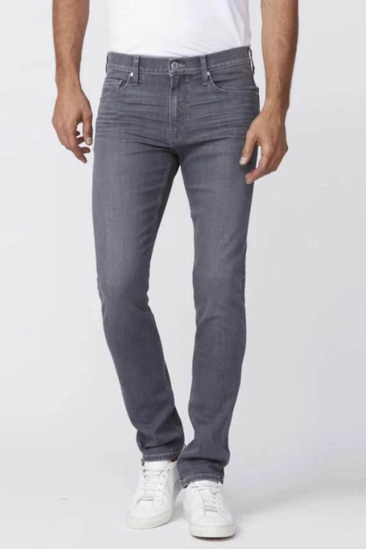 Jeans cintrés Lennox Mickells en délavage gris moyen, portés par un homme avec un t-shirt blanc.