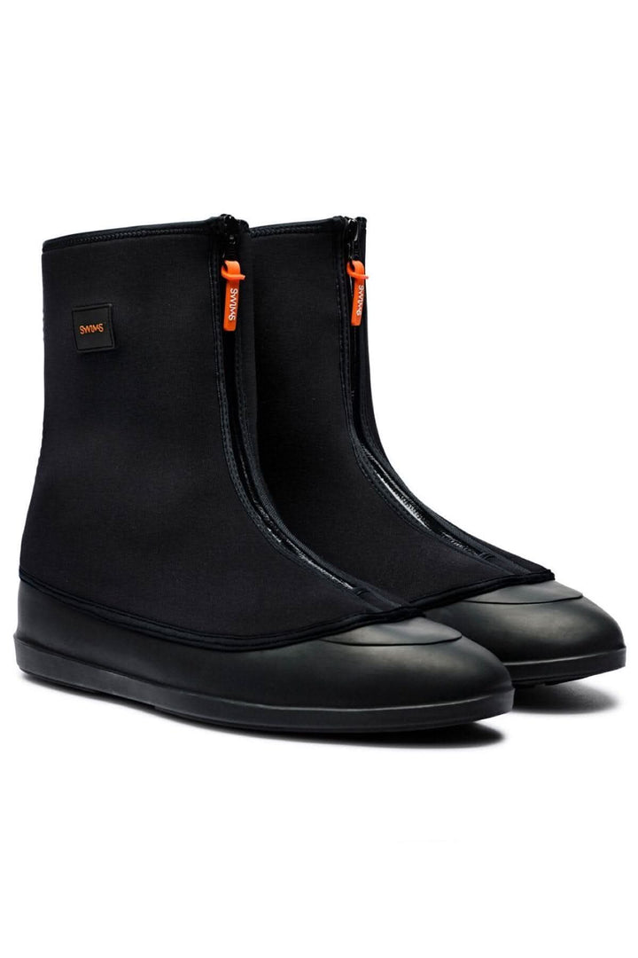 Bottines noires en néoprène et caoutchouc, imperméables et résistantes aux intempéries, idéales pour les matins gadoueux.