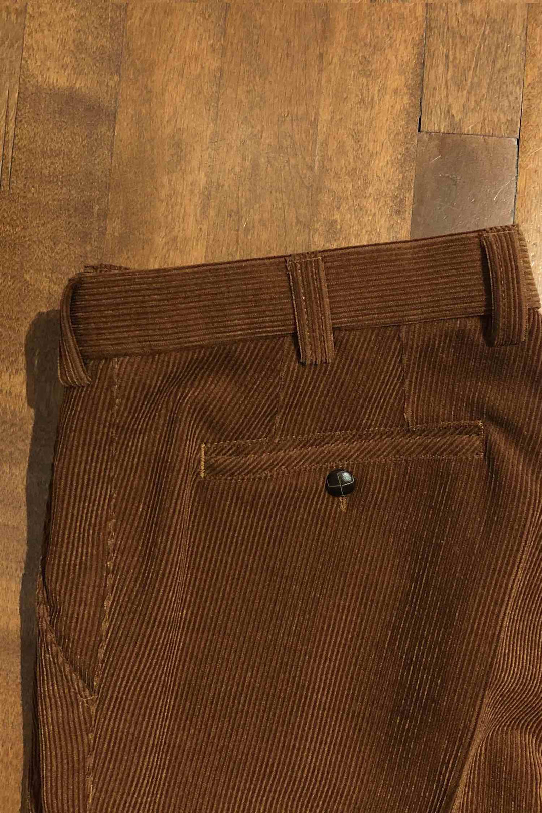 Pantalon en corduroy marron avec ceinture et poche, style éco-responsable, confort optimal, vue en gros plan.