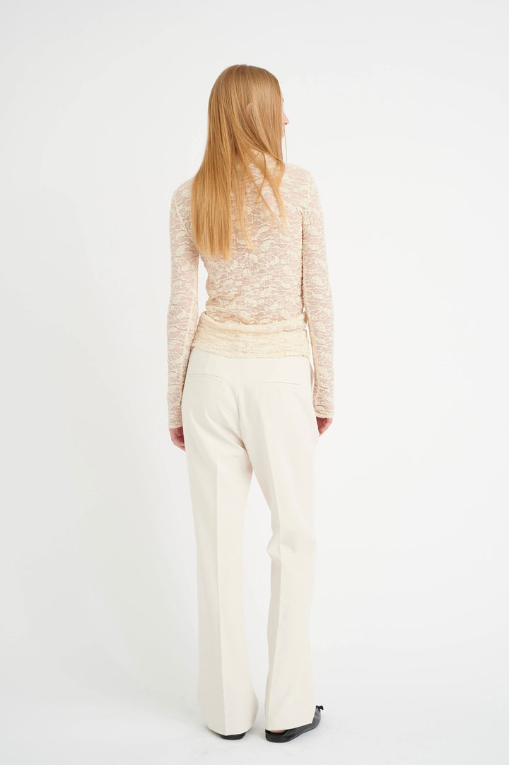 Femme vue de dos portant un pantalon Ibbie, style habillé, jambe droite et longue, dans une teinte claire.