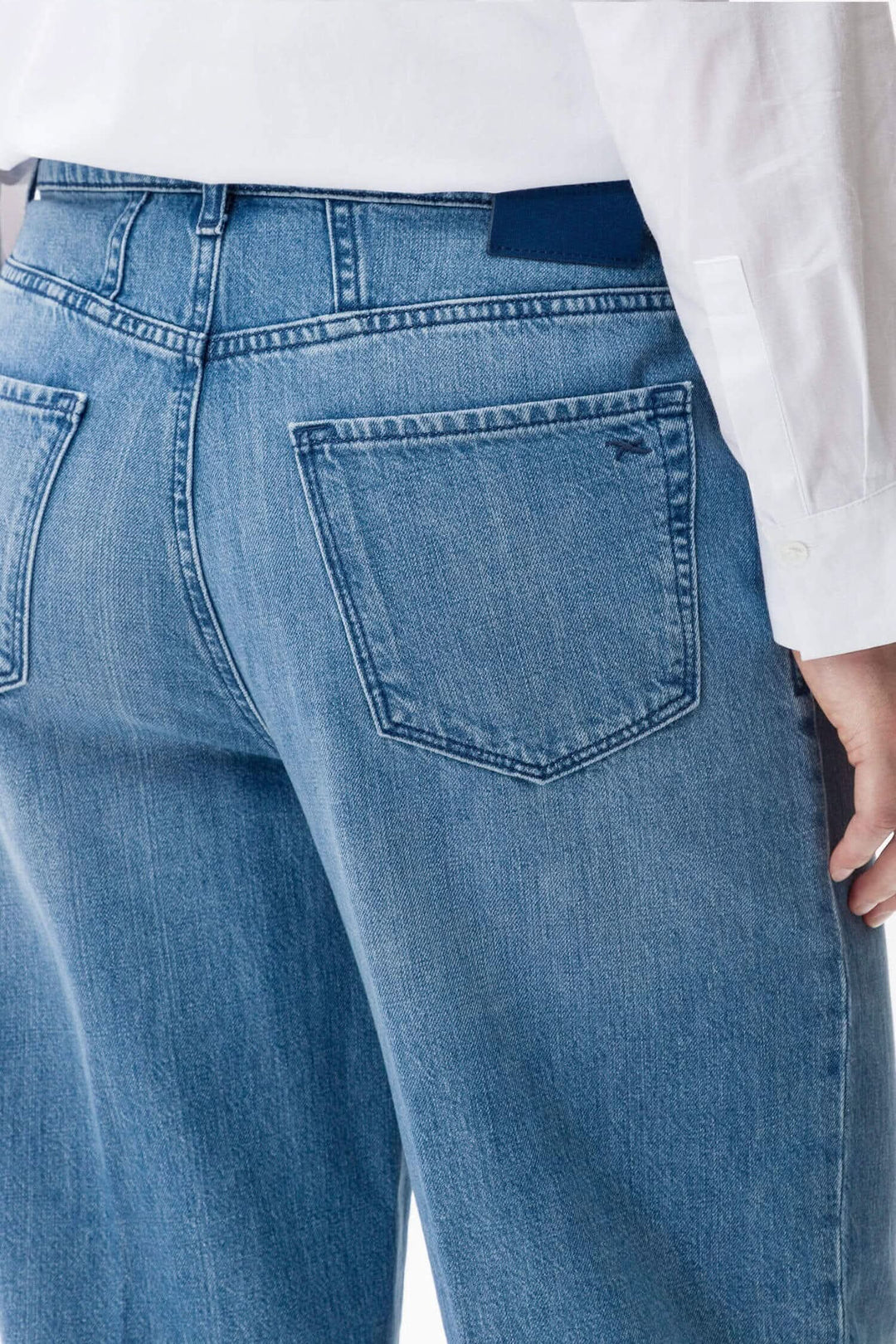 Détails du pantalon Maine avec coupe décontractée et poches au dos, en denim léger.