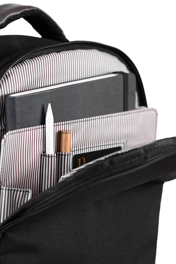 Détail du sac à dos recyclé PKG Durham montrant l'organisation intérieure avec stylos et un carnet.