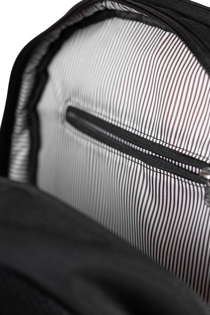 Intérieur du sac à dos recyclé PKG Durham 17L, montrant une poche zippée et un tissu rayé.
