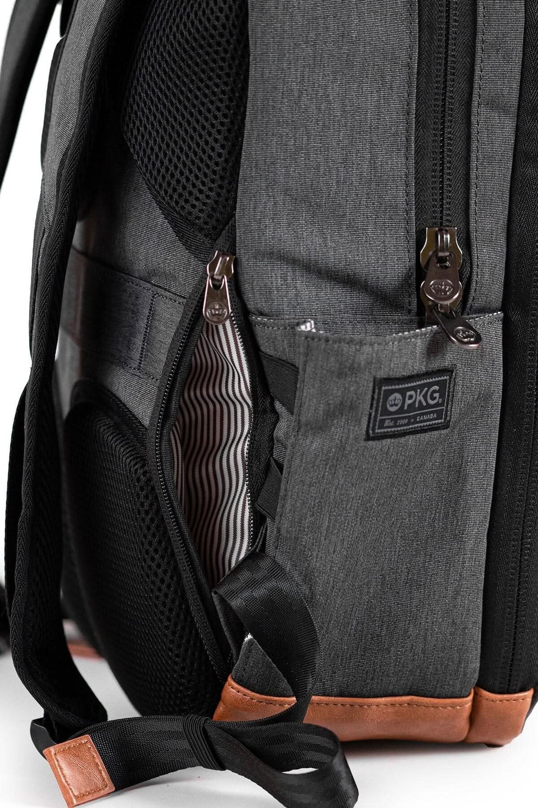 Sac à dos recyclé PKG Durham, vue latérale avec poches et arrière en tissu polyester résistant et zippers.