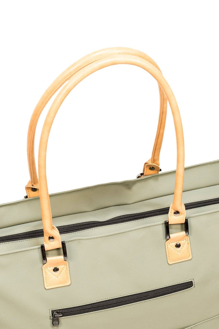 Sac fourre-tout recyclé imperméable avec anses en cuir beige et détails pratiques pour voyages.