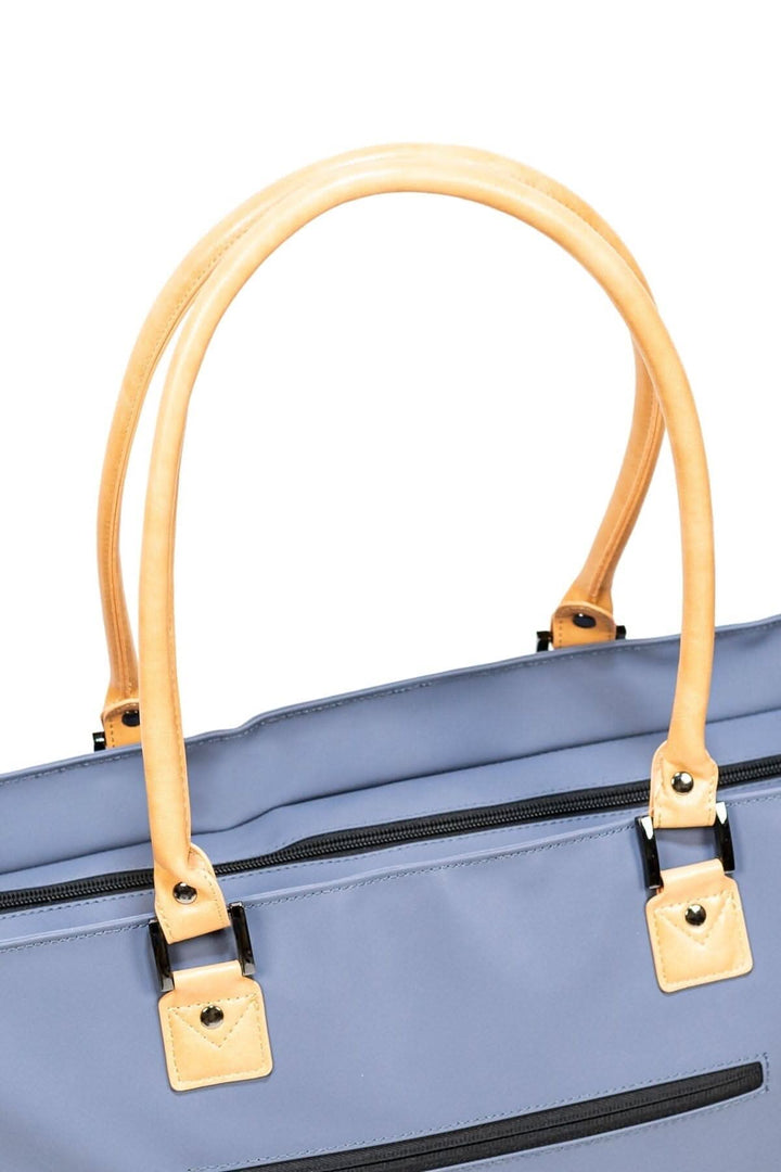 Zoom sur les poignées du sac fourre-tout recyclé de 33L, avec un tissu extérieur imperméable et des détails en cuir.