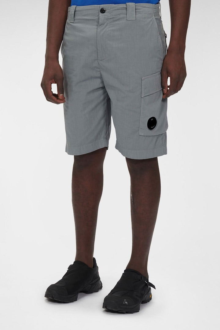 Short cargo stretch gris avec poches et détail emblématique de C.P. Company, idéal pour le confort et la flexibilité.