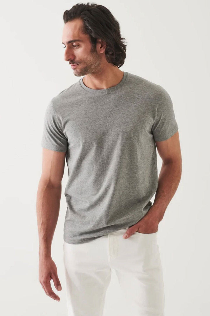 T-shirt basique gris à coupe moderne, porté par un homme avec un look décontracté et élégant.