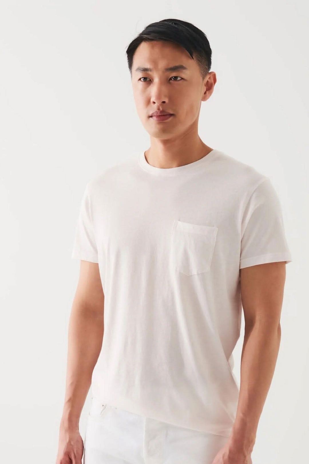 Homme portant un t-shirt léger en coton pima avec poche, idéal pour temps chaud, couleur blanche.