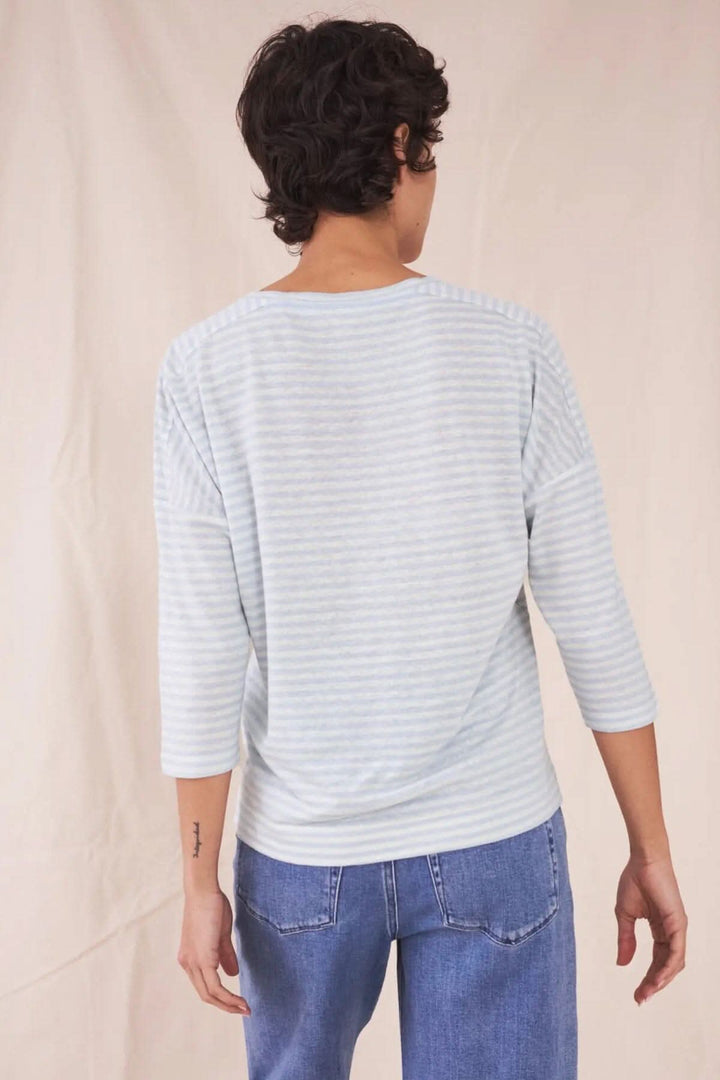 T-shirt Lennox léger et respirant, porté de dos, rayures bleu clair sur fond doux, avec manches trois-quarts.