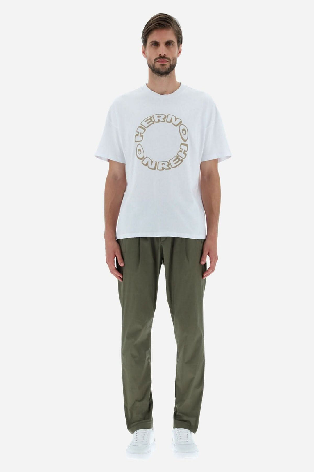 T-shirt blanc HERNO à col ras du cou, lettre graphique, coupe décontractée, porté avec un pantalon kaki.