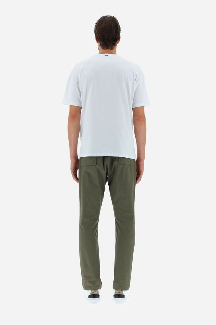 Homme portant un T-shirt HERNO blanc, vu de dos, assorti avec un pantalon olive, style décontracté.