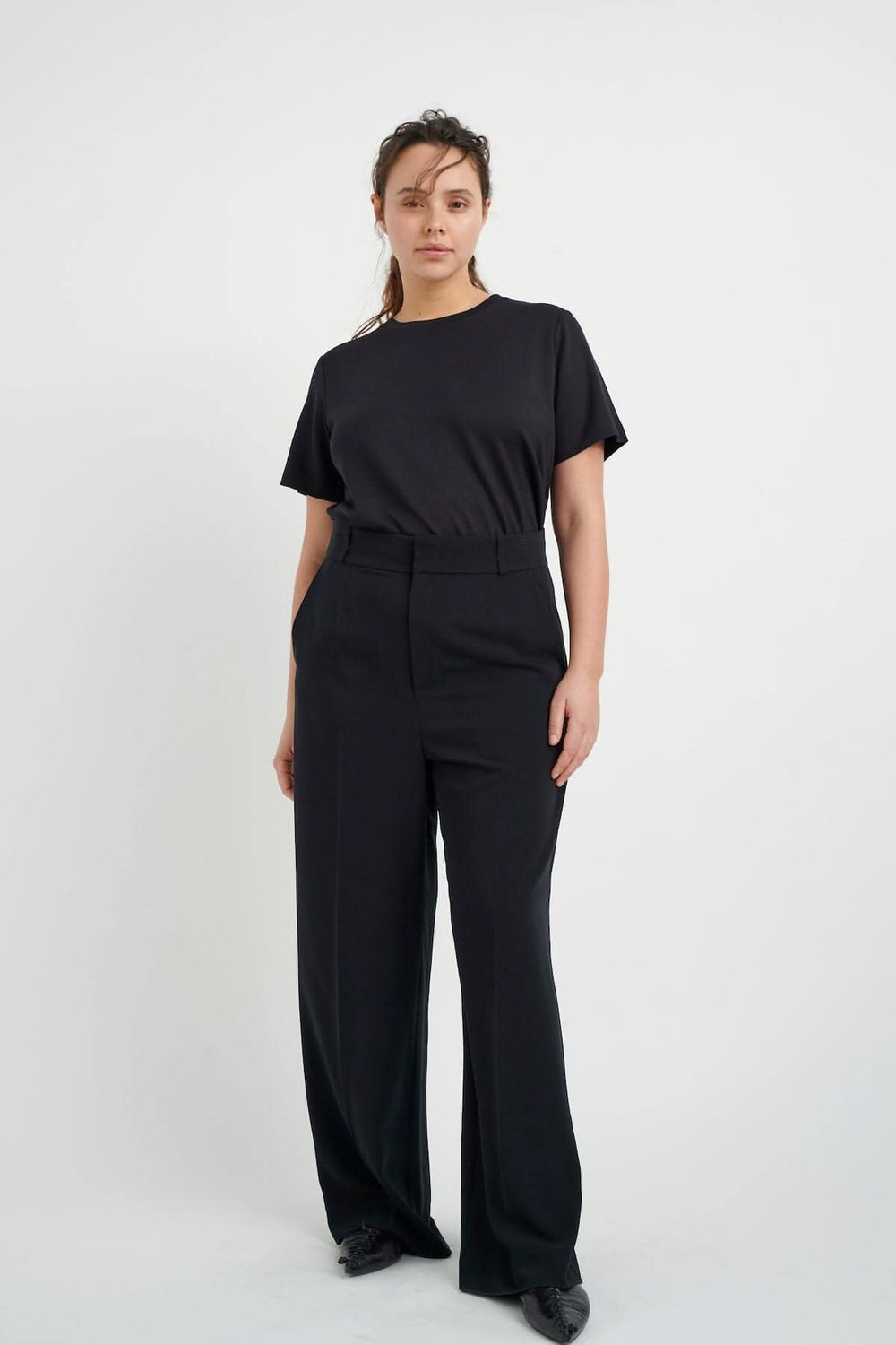 Modèle portant un t-shirt velouté Vincent, coupe classique noire, avec pantalons larges noirs.