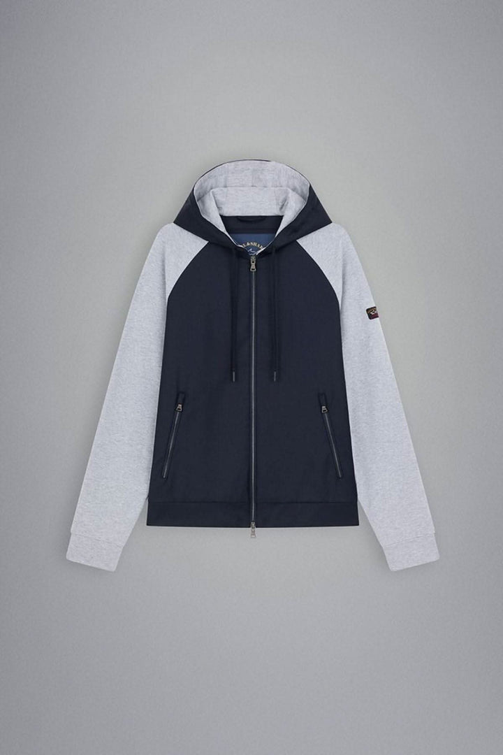 Veste à capuche à zip bleu marine et manches grises, avec logo sur la manche et poches zippées.