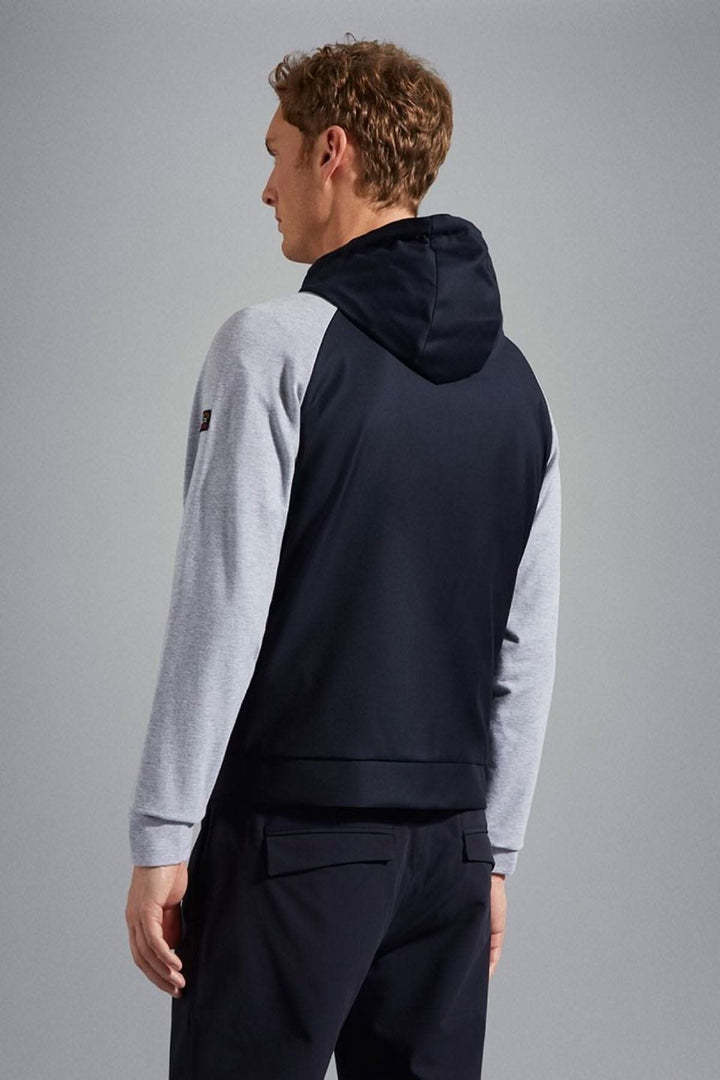 Homme portant une veste à capuche avec logo, vue arrière, coloris bleu marine et gris.
